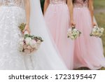Row of bridesmaids with bouquets at wedding ceremony. Three bridesmaids holding wedding bouquets. Bride With Bridesmaids Outdoors At Wedding