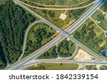 Two-level car interchange top view. Summer, green trees around