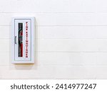Small photo of Red fire extinguisher in fireproof metal box installed isolated on the brick wall, law and regulations of safety for buildings, inside residential and commercial areas. Emergency tools prevent damage.