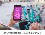 Renting bike using rental app on smartphone. Using bike sharing city service. Paid rent of electric scooter. Using mobile phone to rent and pay for public eco transport. Bike sharing city station