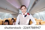 Small photo of Attractive young Asian stewardess in uniform looking and smiling to the camera in airplane, Cabin crew or air hostess occupation concept