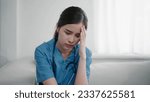 Small photo of Tired depressed young asian woman nurse in uniform suffer from headache after hard working. Exhausted sad woman doctor feels burnout stress. Physician burnout