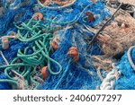 Small photo of Industrial Fishing Equipment Fishnets and Fishing Lines lying on concrete in the port, fishing industry