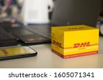Small photo of Payathai Bangkok / Thailand - Jan 4th 2020 : The Small DHL Box is on table and nealy with laptop. Smart show DHL application nealy the keyboard. Focus on the box
