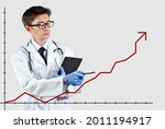 Small photo of The doctor looks at the growing chart. The concept of increasing morbidity, vaccination and mortality. A man in a doctor's suit on a white background.