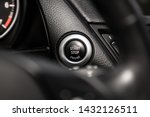 Car engine push start stop button ignition remote starter. Car dashboard:  black engine start stop button, car interior details. Soft focus