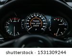 Close up Instrument automobile panel with Odometer, speedometer, tachometer, fuel level, which says Happy New Year 2020. The concept of the new year and Christmas in the automotive field