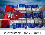 The national flag of Cuba on a large number of metal containers for storing goods stacked in rows on top of each other. Conception of storage of goods by importers, exporters