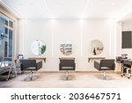 Modern bright beauty salon. Hair salon interior business with black chairs, round mirrors and neon lights.