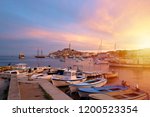 Rovinj, old costal town of Croatia in golden sunrise light. Motorboats, boats and yachts on water in port of Rovinj. High tower of Church of Saint Euphemia. Istra region, popular touristic destination