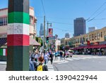 San Francisco urban cityscape: street pole painted with the Italian flag colors at North Beach, known as Little Italy and blurred pedestrians crossing the street on sunny day