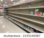 A baby formula display sits empty at supermarket as a result of nationwide baby formula shortage. Abstract blur. 