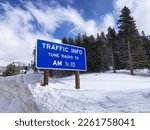 Traffic Info Tune Radio To 1610 AM road sign on winter highway covered with heavy snow.