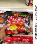 Small photo of Puchong, Selangor, Malaysia- 22 December 2017; Hand holds Packages of Samyang ramen instant noodle in supermarket. Samyang ramen was one of the spiciest korean ramen instant noodles in the market.