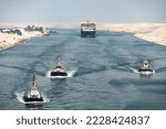 Small photo of Huge cargo ships with pilot boats navigate by Suez Canal, Egypt. Concept of transportation and logistics