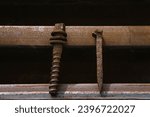 Small photo of One very old rusty railroad spike and one rusty screw spike lay on two old rusty rails, close up photo, rusty eaten spikes