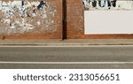 Small photo of Brick wall covered with ripped billboards except one blank on the right. Sidewalk and urban street in front. Grunge background for copy space.