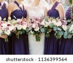 Bride with Bridesmaids in Purple Dresses Holding White and Purple Bouquets