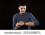 Small photo of man with wrist watch on arm look to look to pointer and see it is time to turn back the clock and set forward one hour so you will lose one hour or set back to Daylight Saving time