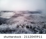 Top view of snowy conifer crowns. Nature pattern. Drone shot.