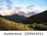 Stunning view of the St. John Church  (San Giovanni in Ranui ) that stands out in the green meadows, in the heart of the beautiful Dolomitic mountain landscape, Val di Funes, Itaty.	