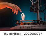 Small photo of 3D printing in progress. 3d printer printed a hand. A man touches the product printed on a 3d printer. God's touch, biblical motives. High quality photo