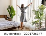 Small photo of Woman wake up with a fresh and open the curtains on the windows.