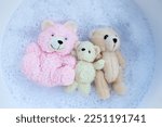 Small photo of Soak toy teddy bear in laundry detergent water dissolution before washing. Laundry concept, Top view