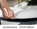 Close up of hands being open the car hood or bonnet for maintenance checking engine  before a trip or journey, Car check condition concept.