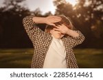 Photophobia Light Sensitivity content. Boy covering eyes by hand from sunlight. Sun Damage to Eyes Reversible