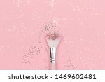 Makeup brush and shiny sparkles on pastel pink background. Festive magic makeup concept. Template for design, Top view Flat Lay Copy space.