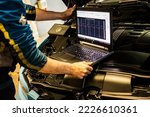 Small photo of Milan, Italy 13 November 2022: Mechanic perform chip tuning on tuned car in a garage workshop