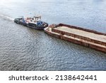 A River Tug Slowly Pushes An...