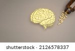 Small photo of Brain shape made from paper and pills capsules with a bottle on a gray background. Awareness of Alzheimer's, Parkinson's disease, dementia, stroke, seizure, or mental health