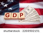 GDP or gross domestic with wooden cubes or blocks on the American flag background. Business and growth of GDP, domestic product concept. Top view