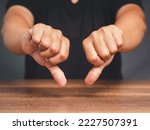 Negative concept. Close-up of young man's hands showing a thumbs down for dislike service. Customer service and satisfaction surveys concept