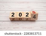 Business planning and countdown to 2025. Flipping 2024 to 2025 on wooden cubes on a wooden table