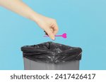 Small photo of throw the skewer for appetizer, skewer for appetizer, plastic skewer for canapes in hand in front of the trash can, recycling concept