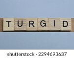 Small photo of text the word turgid from brown wooden small letters with black font on an gray table