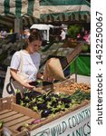 Small photo of London, UK - July, 2019. Young people shopping organic vegetables in a local farmer's market in Brockley, South-East London.