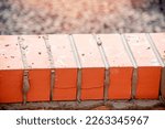 Small photo of Close up of a brick wall and jointer trowel used by the worker to apply and level the mortar between bricks. Bricklayer making finishing touches to the brick wall and filling joints with mortar