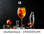 Classic italian aperol spritz cocktail in glass. liquid splash, freeze motion in jar glass on dark background.