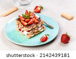 Strawberry tiramisu with mascarpone. Summer dessert, classic tiramisu with strawberries decorated with mint leaves.