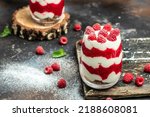 Small photo of Raspberry dessert cheesecake, trifle, mouse in a glass. Raspberry Greek yogurt granola parfait on a dark background. Restaurant menu, dieting, cookbook recipe.