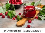 Small photo of Raspberry jam with berry on light background. Homemade jam with raspberry. banner, menu, recipe place for text, top view