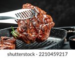 Grilled pork steaks, pork neck with herbs and spices on the grill pan, Restaurant menu, dieting, cookbook recipe place for text.