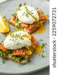 Small photo of poached egg on toast with salmon, lettuce salad, Delicious breakfast or snack, Clean eating, dieting, vegan food concept. top view