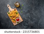 Small photo of fast food chicken nuggets with ketchup on a wooden board, banner, menu, recipe place for text, top view