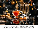 Small photo of glass of champagne with red caviar appetizer cracker, butter and red caviar. banner, menu, recipe. selective focus, place for text.