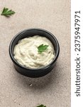 Small photo of Delicious tartar, garlic mayonnaise sauce on a light background. vertical image. top view. place for text.